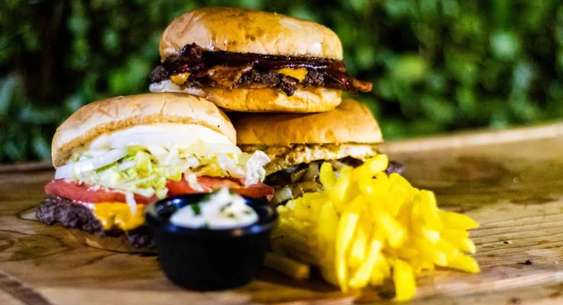 Hamburguesas con papas fritas sobre tabla de madera